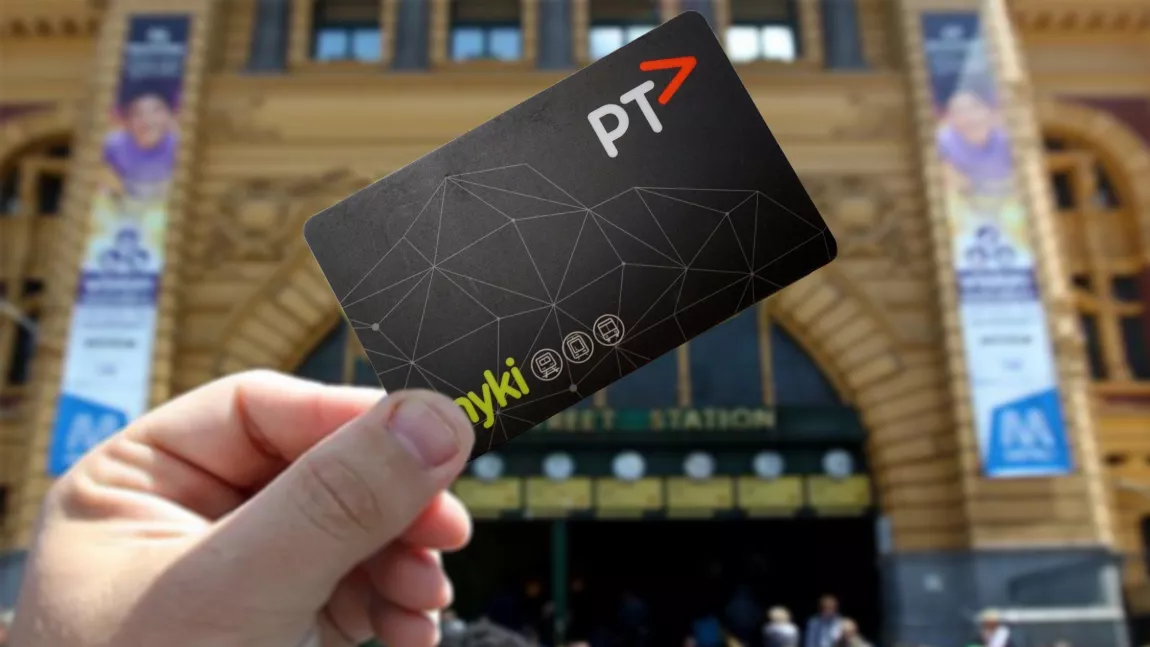 A person holding a myki in front of Flinders Station